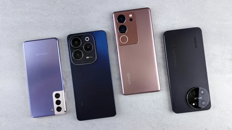 Neljä Android-älypuhelinta harmaalla pinnalla, takakuoret ja kameramoduulit näkyvissä Samsung, Infinix, Vivo ja realme.