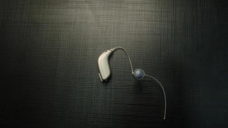 Hopeanharmaa korvantauskuulokoje, ohut letku ja silikoninen tulppa tummalla teksturoidulla pinnalla.